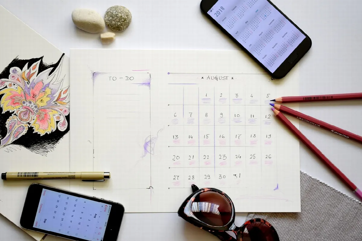 Mesa com calendário editorial e laptop aberto